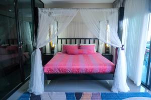 a bedroom with a red bed with a canopy at The Longhouse Luxury Boutique Resort in Sakon Nakhon +94 photos