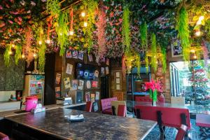 a restaurant with a table and flowers hanging from the ceiling at The Longhouse Luxury Boutique Resort in Sakon Nakhon