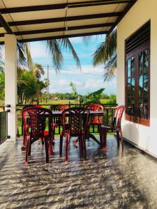 a table and chairs on the porch of a house at Lumora Resort in Horuwila