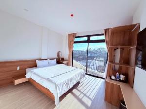 a bedroom with a bed and a large window at The SunHill in Da Lat