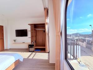 a room with a bed and a window with a view at The SunHill in Da Lat