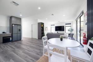a kitchen and living room with a white table and chairs at Winchester Residence in Armadale