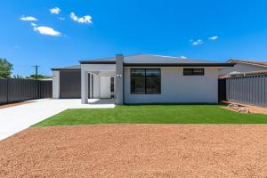 a house with a grass yard in front of it at Winchester Residence in Armadale