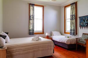 a bedroom with two beds with a stuffed animal on the bed at Cliff Cottage - Noraville in Norah