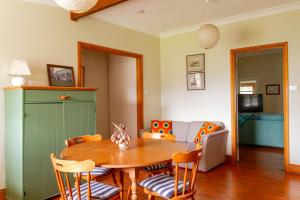 a living room with a table and chairs and a couch at Cliff Cottage - Noraville in Norah