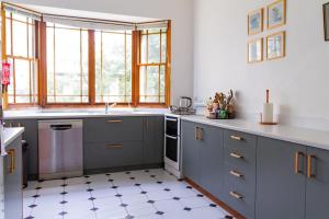 a kitchen with gray cabinets and a white floor at Cliff Cottage - Noraville in Norah +8 photos