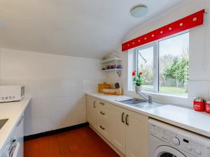 a kitchen with a sink and a window at Hall Farm Bungalow in Shirley +11 photos