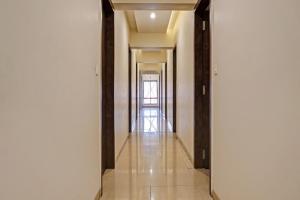a hallway with white walls and a long hallway with wooden beams at Collection O Royce Studios Near Pune Airport in Pune