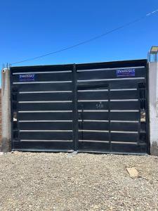 a black garage door with two signs on it at Endless Salt in Colchani