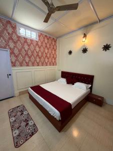 a bedroom with a bed and a ceiling fan at Vina Homestay in Jorhat +1 photo