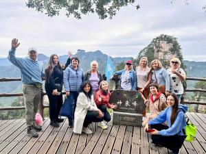 a group of people posing for a picture in front of the mountain at Zhangjiajie Cloudscape Villa - New Hotel, Free Private Car Rides to South & East Gates of Zhangjiajie National Forest Park,Free Private Car Rides to & from Airport,Chinese-Western Breakfast, Coffee, Tea & Fruit, Free Laundry & Dryer, Ticket Guidan in Zhangjiajie