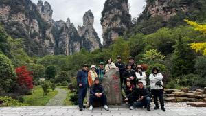 a group of people posing for a picture in front of a mountain at Zhangjiajie Cloudscape Villa - New Hotel, Free Private Car Rides to South & East Gates of Zhangjiajie National Forest Park,Free Private Car Rides to & from Airport,Chinese-Western Breakfast, Coffee, Tea & Fruit, Free Laundry & Dryer, Ticket Guidan in Zhangjiajie +135 photos