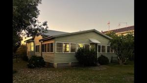 a small house in a yard with at Cliff Cottage - Noraville in Norah