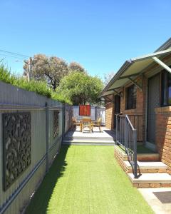 a backyard with a fence and grass at 2-Bedroom Townhouse Next to the Hospital in Bendigo