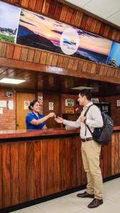 a man and a woman standing at a bar at Hotel Pacífico Talara in Talara
