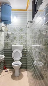 a bathroom with a toilet and a sink at Krishna Holiday Guest House in Dharmsāla +42 photos