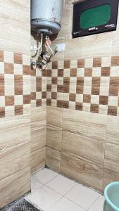 a bathroom with a checkerboard tile wall with a toilet at Krishna Holiday Guest House in Dharmsāla