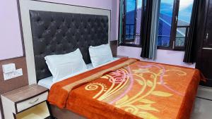 a bedroom with a large bed with a large headboard at Krishna Holiday Guest House in Dharmsāla