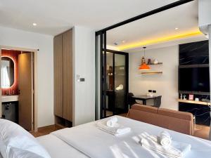 a bedroom with a white bed and a living room at J5 Hotel in Ban Zong Katiam +8 photos