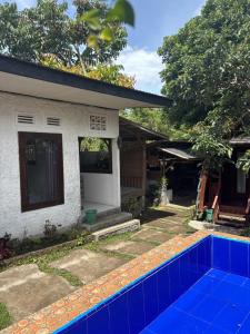 ein Haus mit einem blauen Swimmingpool davor in der Unterkunft Azalea2 in Bumiagung