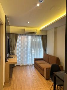 a living room with a couch and a table and a television at J5 Hotel in Ban Zong Katiam