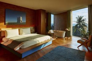 a bedroom with a large bed and a bathroom with a tub at Desa Potato Head Bali in Seminyak +97 photos