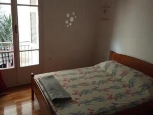 a bedroom with a bed with a floral comforter and a window at Mary Mary! in Agios Kirykos