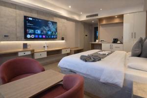 a hotel room with a bed and a tv on the wall at MoonBasa Boutique Hotel and Spa Infopark , Kakkanad in Cochin