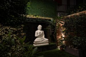 a statue of a woman sitting in a garden at MoonBasa Boutique Hotel and Spa Infopark , Kakkanad in Cochin