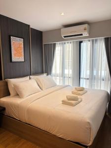 a bedroom with a large bed with towels on it at J5 Hotel in Ban Zong Katiam
