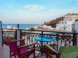 a balcony with chairs and a table and the ocean at Nikos Hotel in Diafani