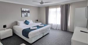 a bedroom with a large bed and a window at Sussex Shores in Sussex Inlet