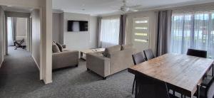 a living room with a couch and a table and chairs at Sussex Shores in Sussex Inlet