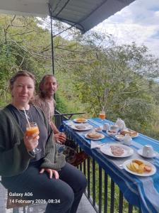 a man and a woman sitting at a table with food at Green Mount Eye Ella in Ella