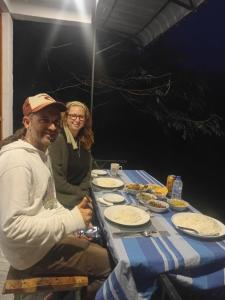a man and a woman sitting at a table with food at Green Mount Eye Ella in Ella +11 photos
