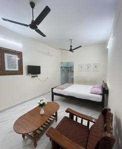 a room with a bed and a couch and a table at Gravity Groups AARA Residency - Near Jipmer in Puducherry Airpoert