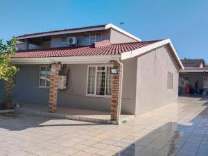 a small white house with a red roof at Silverstreams Guest house in Mthatha