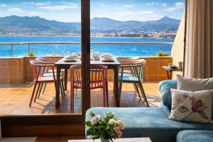 a balcony with a table and chairs and a view of the ocean at Holibai, Son do mar apto con terraza y vistas a la bahia de Baiona in Baiona