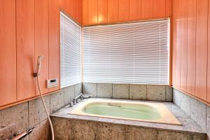 a bath tub in a room with a window at holidayhouse SERENADE in Nasu +25 photos