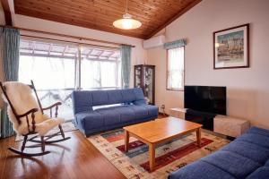 a living room with a blue couch and a table at holidayhouse SERENADE in Nasu