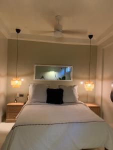 a bedroom with a large bed with two lights at Shella Home Stay in Miagao
