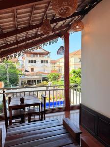 a room with a table and a balcony with a view at Vientiane Villa Ruby Hotel in Vientiane