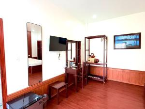 a room with a mirror and a tv and a bed at Vientiane Villa Ruby Hotel in Vientiane