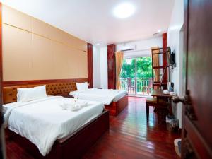 a hotel room with two beds and a balcony at Vientiane Villa Ruby Hotel in Vientiane +22 photos