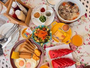 a table topped with plates of breakfast foods and drinks at Prim's Cottage Khaokho พริม คอทเทจ เขาค้อ วัดผาซ่อนแก้ว in Khao Kho