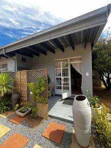 a house with a porch with a large vase in front of it at Bird Song in Roodepoort