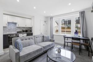 a living room with a couch and a table at The Quayside Apartments - Central, Steps to Gloucester Quays, Parking and Smart TV in Gloucester