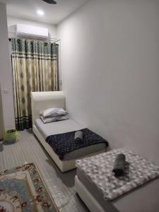 a bedroom with two beds and a window at QA Homestay in Tawau