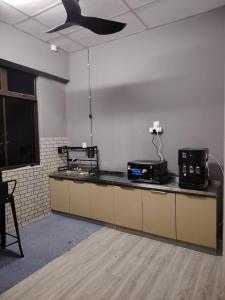 an empty room with a kitchen with a ceiling fan at Ayla Hostel at MITC in Ayer Keroh