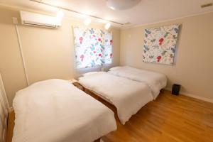 two beds in a room with a window at Lilla nasu in Nasu